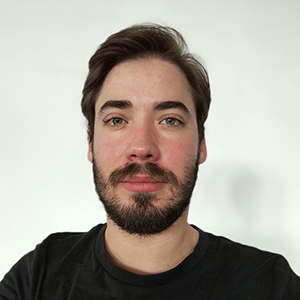 Fotografia de Rodrigo Owen, um homem de cabelo castanho e olhos claros com barba cuidada. Veste uma camisola preta em contraste com o fundo branco, comum em fotos corporativas.
