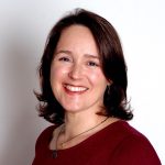 Fotografia de Filipa Pico, uma mulher de olhos e cabelo castanhos com um largo sorriso para a câmera. O fundo é branco, comum em retratos corporativos contrastando com a camisola vermelha.