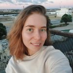 Fotografia de Oleksandra Khalimon, uma mulher de cabelo castanho claro e olhos verdes a sorrir levemente para a câmara. Veste uma camisola creme e o fundo é num ambiente outdoor, conferindo um ar descontraído.