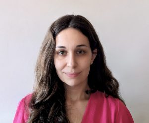 Fotografia de Ana Sofia Manco, uma mulher de cabelo e olhos castanhos, a sorrir levemente para a câmara. Veste uma camisola rosa e o fundo é branco, comum em fotos corporativas.