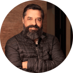 Fotografia de Fernando Barreira, um homem de cabelo preto, olhos castanhas e barba a sorrir para a câmera.